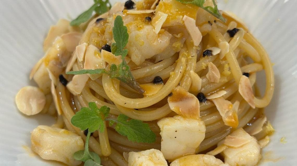 Spaghettone trafilato al bronzo, con aglio nero, zest di limone e mandorle tostate (Buca di Bacco)