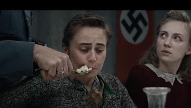 Una delle assaggiatrici imboccata con la forma da un gerarca nazista nel film