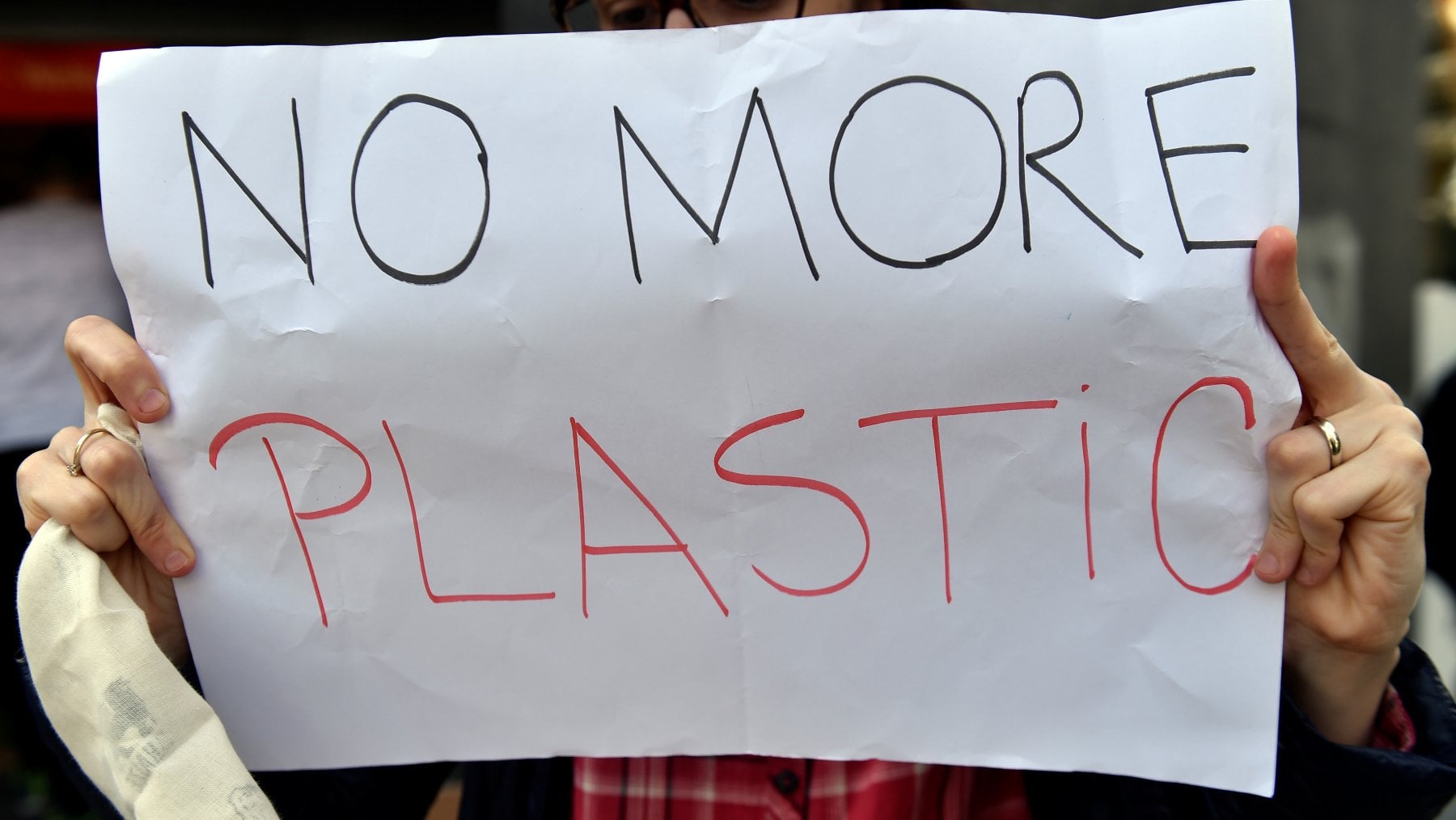 Un'attivista partecipa ad un 'Plastic Attack' davanti a un negozio di Bruxelles