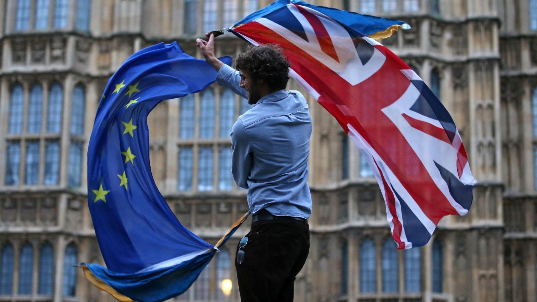 Nella foto scattata nel 2016 davanti al Parlamento britannico di Londra, un uomo protesta contro la Brexit sventolando la bandiera dell'Ue e quella inglese