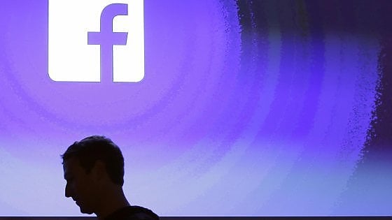 La silhouette di Mark Zuckerberg di profilo con il logo di Facebook sullo sfondo