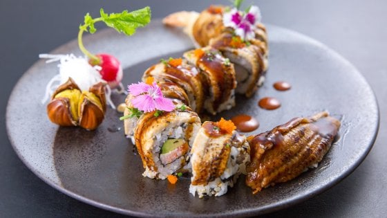 New Dragon roll, roll con polpa di granchio, avocado, anguilla kabayaki e masago. Con gambero in tempura