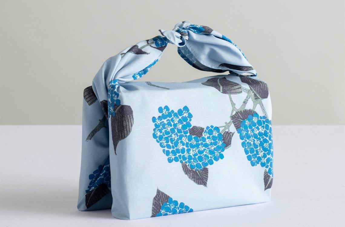 L'artista Ito Jakuchu firma per Uniqlo la collezione di&nbsp; tessuti pensati per i furoshiki. Qui un esempio con manico che avvolge due libri (tecnica&nbsp;Hon Tsutsumi)