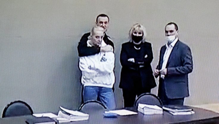 Aleksej Navalnyj abbraccia la moglie Julija durante una pausa dell'udienza. Al loro fianco, i legali Olga Mikhailova e Vadim Kobzev