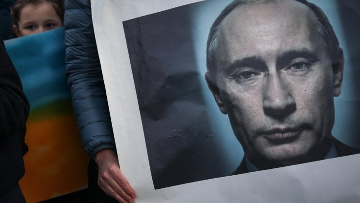 Manifestanti per la pace con un ritratto di Putin