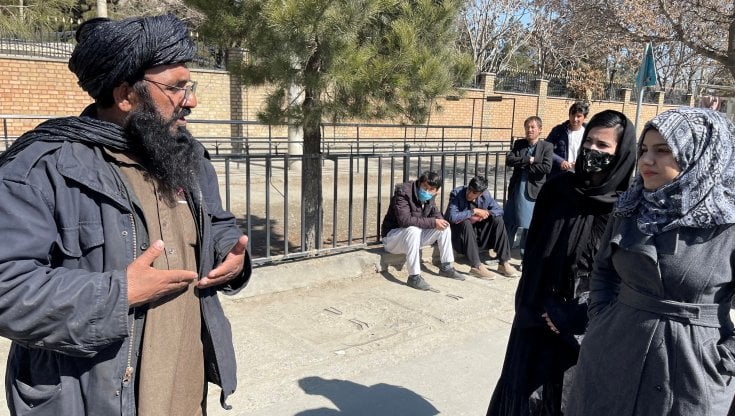 Un membro dei talebani con due studentesse all'ingresso dell'universit&agrave; di Kabul