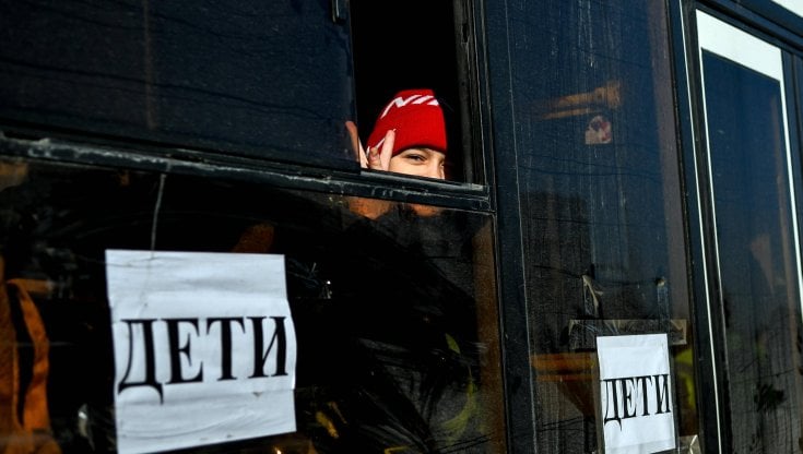 Una bambina sfollata da Mariupol verso Berdiansk fa il segno della vittoria