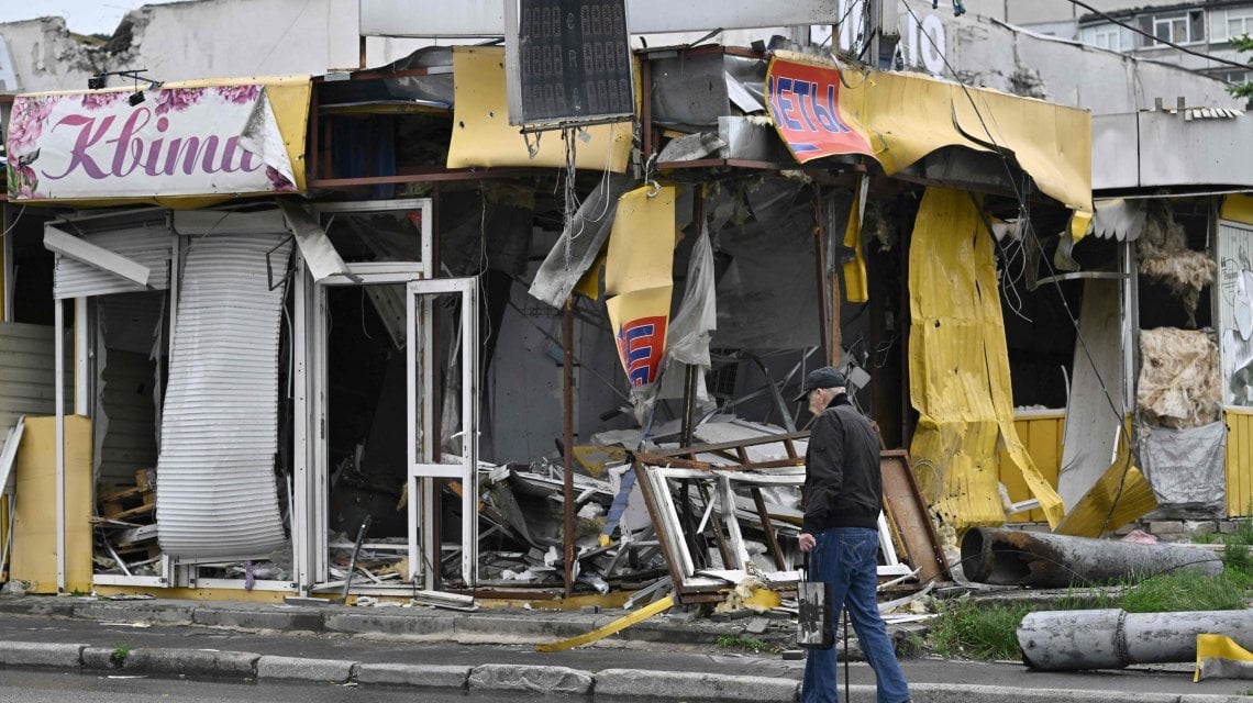 A local resident walks past a destroyed small shop in the Saltivka district, northern Kharkiv on May 29, 2022, amid Russian invasion of Ukraine