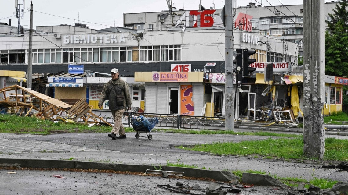 Local resident Ivan Mykhaylovych, 80, walks in front of a damaged building in the Saltivka district, northern Kharkiv on May 29, 2022, amid Russian invasion of Ukraine