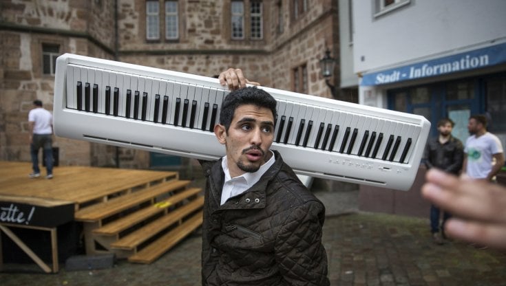 Il musicista in Germania (dove vive in esilio con la famiglia) tiene in spalla la pianola prima di un concerto. 