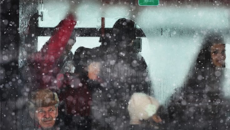Sotto, i passeggeri di un autobus a Bucarest durante una tempesta di neve, e a destra uno scorcio del centro storico della citt&agrave; (Getty images)