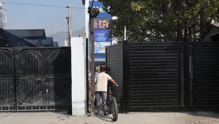 Un ragazzo supera le barriere di sicurezza all'ingresso del cinema Inox, a Srinagar, in India (foto Ansa)