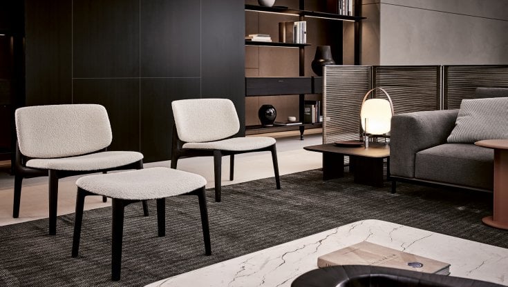La poltrona Curve di Poliform, in questa versione con struttura in olmo nero e rivestimento in tessuto bianco. Molti rivestimenti e finiture alternativi