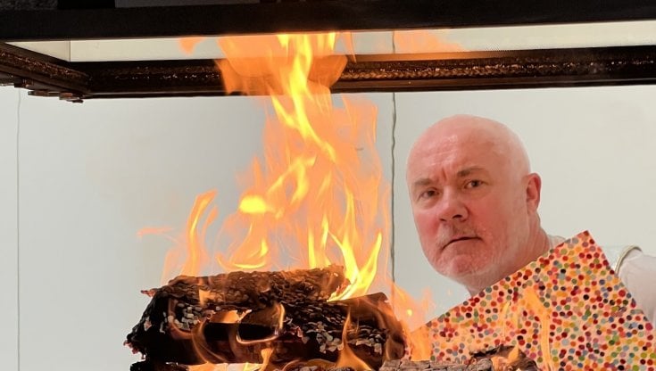 L'artista inglese Damien Hirst mentre brucia le sue opere