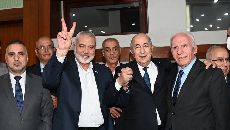Il leader di Hamas Ismail Haniyeh festeggia ad Algeri con accanto il presidente algerino Abdelmadjid Tebboune e il dirigente di Fatah Azzam al-Ahmad