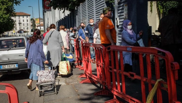 Persone in fila ad una mensa per i pi&ugrave; bisognosi