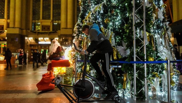Un ragazzo aziona le luci dell'albero di Natale della stazione di Kiev