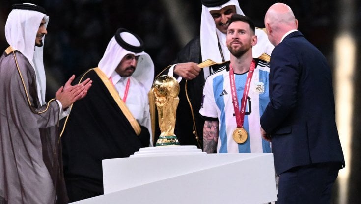 Messi nell'atto di ricevere la coppa del mondo, quella vera