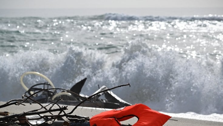 Resti di vestiti, un giubbotto di salvataggio e pezzi di legno arenati sulla spiaggia di Cutro