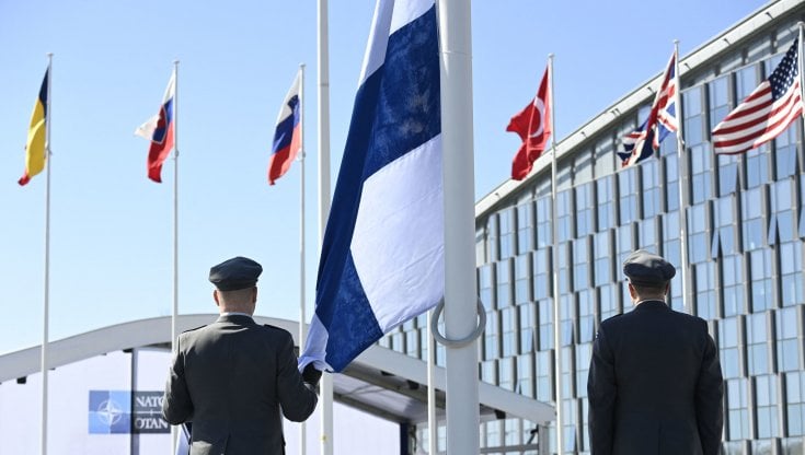 Militari finlandesi issano la bandiera della Finlandia davanti alla sede Nato di Bruxelles