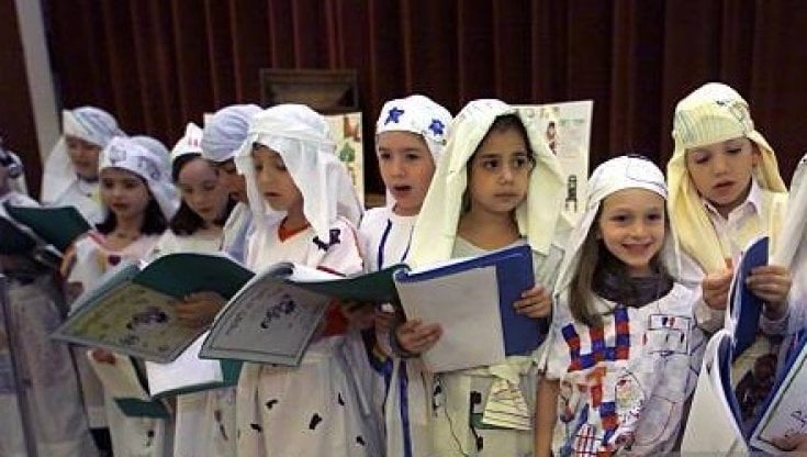 Bambini della scuola ebraica celebrano la Pasqua cantando e recitando vestiti in costume
