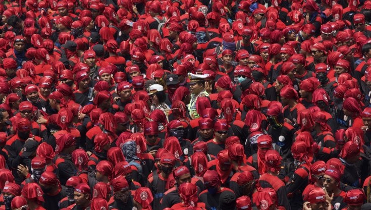 Due poliziotti attraversano una manifestazione&nbsp;di lavoratori&nbsp;a Jakarta nel 2015 (Gettyimages)