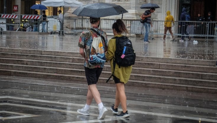 Turisti con l'ombrello in piazza Duomo a Milano: anche per il weekend del Primo maggio &egrave; prevista pioggia su gran parte dell'Italia