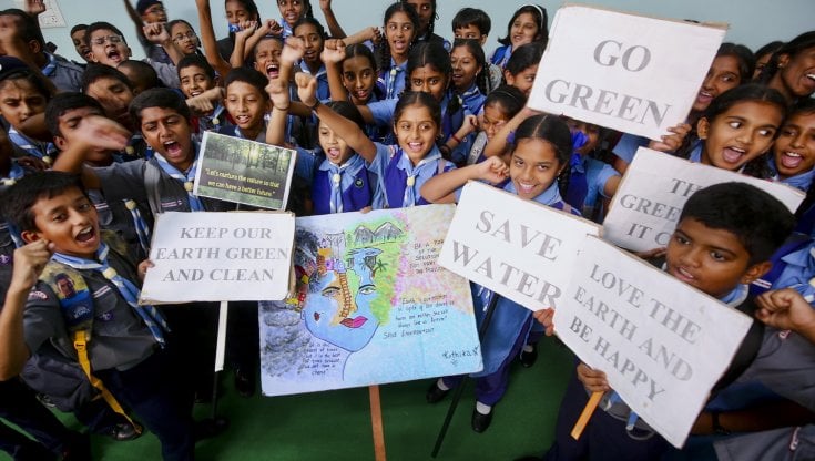 Un gruppo di scolari indiani mostra slogan a favore dell'ambiente durante il World Environment Day