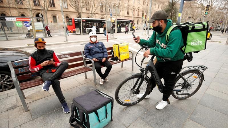 Riders in attesa di ricevere gli ordini sullo smartphone
