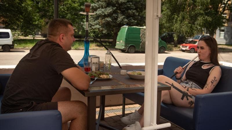 Il Narghile&rsquo; bar&nbsp; nel centro&nbsp;di Kramatorsk. La ragazza sfoggia il tatuaggio&nbsp;di un fucile d&rsquo;assalto M16 (Foto di Alessio Romenzi)
