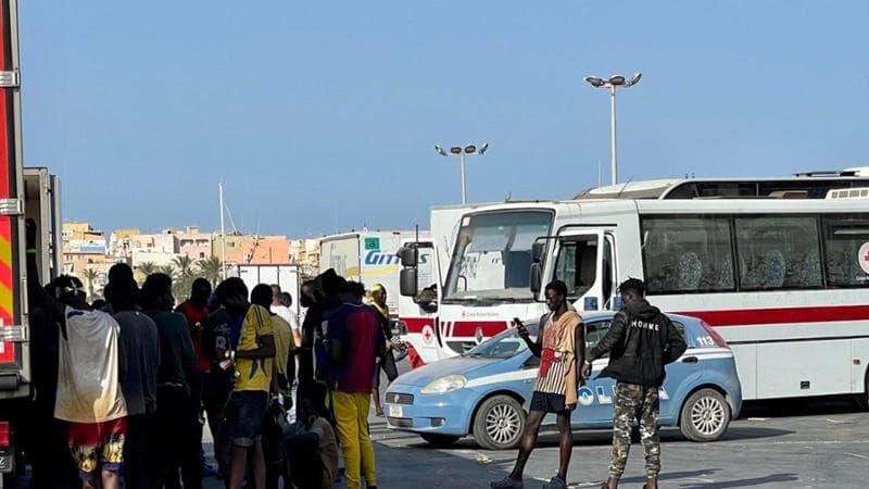 Migranti in attesa di essere trasferiti dal porto di Lampedusa
