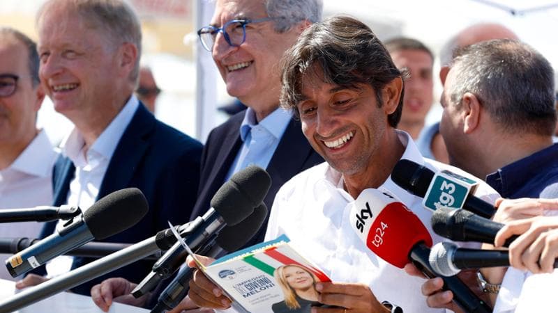 Giovanni Donzelli legge il volantino con all&rsquo;interno Cruciverba dei patrioti&nbsp;
