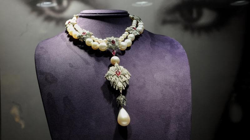 La celebre perla Peregrina in un gioiello appartenuto a Elizabeth Taylor (suoi gli occhi sullo sfondo) e messo all&rsquo;asta nel 2011: nel Cinquecento Filippo II di Spagna l&rsquo;aveva donato alla moglie Maria d&rsquo;Inghilterra (Getty images)
