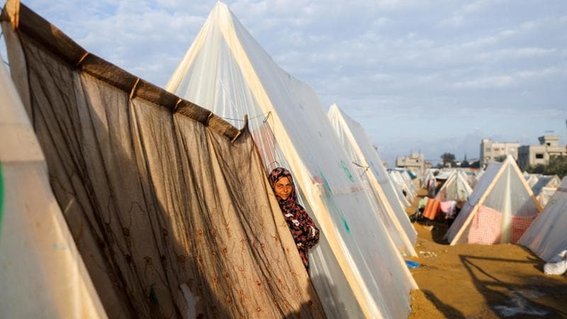 A displaced Palestinian woman, who fled her home due to Israeli strikes, stands amidst the tents in a camp where she takes shelter, amid the ongoing conflict between Israel and the Palestinian Islamist group Hamas, in Rafah, southern Gaza Strip, January 5, 2024. REUTERS/Saleh Salem