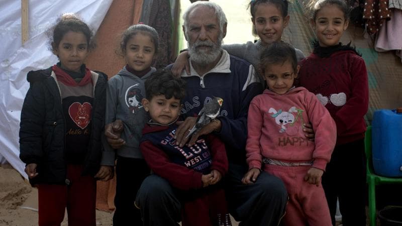 Hajj Adel Gouda in una foto in posa con i suoi nipoti in un campo rifugiati a Rafah
