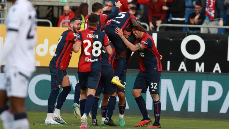 I giocatori del Cagliari esultano dopo l'autogol di Calafiori
