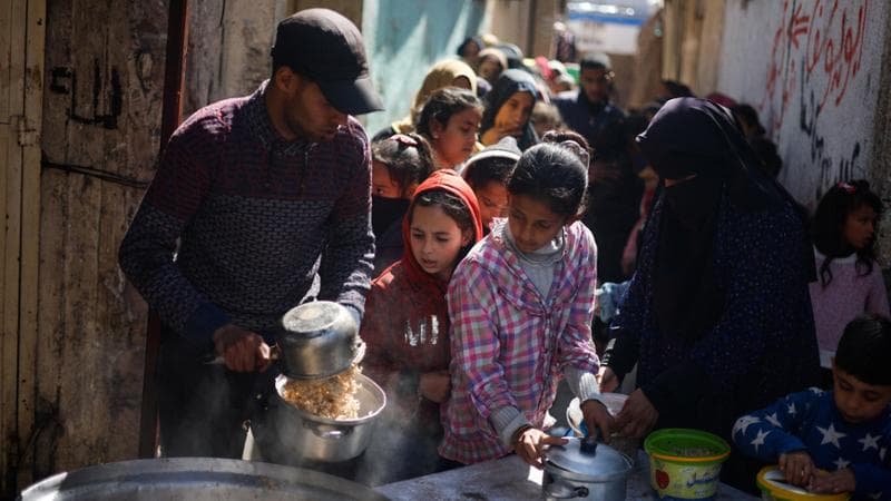 Palestinian children wait to receive food cooked by a charity kitchen amid shortages of food supplies, as the ongoing conflict between Israel and the Palestinian Islamist group Hamas continues, in Rafah, in the southern Gaza Strip, March 5, 2024. REUTERS/Mohammed Salem
