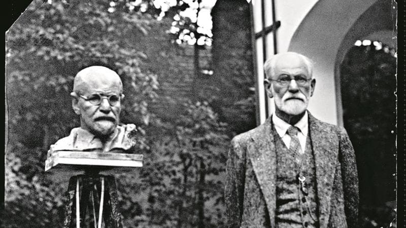 Sigmund Freud (1856-1939) accanto a una scultura che lo rappresenta