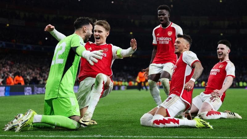 I giocatori dell'Arsenal festeggiano il portiere Raya