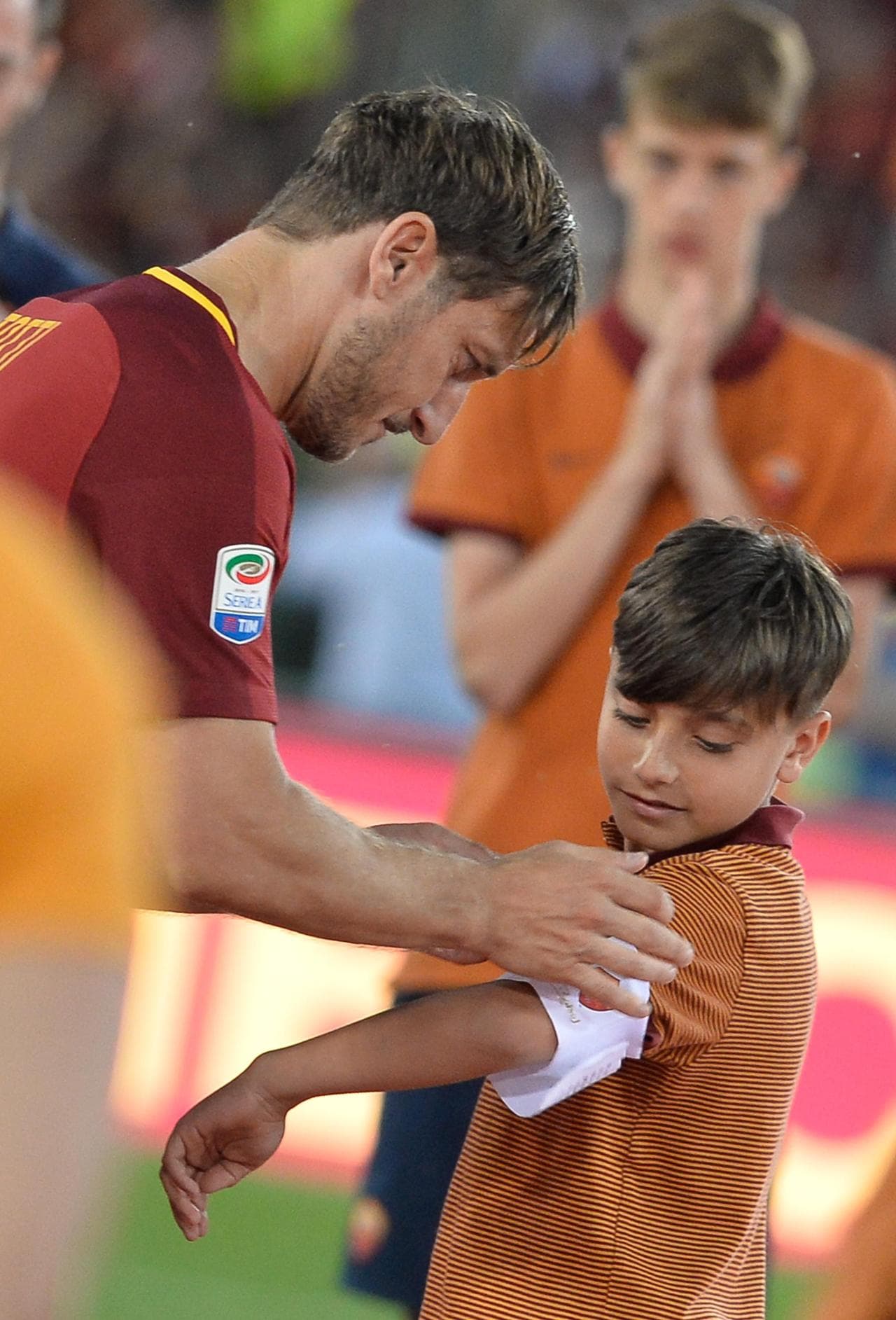 Francesco Totti mette la fascia da capitano al braccio di Mattia Almaviva