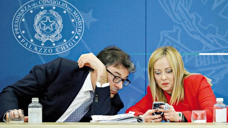 FILE PHOTO: Italian Prime Minister Giorgia Meloni checks her mobile phone with Economy Minister Giancarlo Giorgetti at a news conference for her government's first budget in Rome, Italy November 22, 2022. REUTERS/Remo Casilli/File Photo