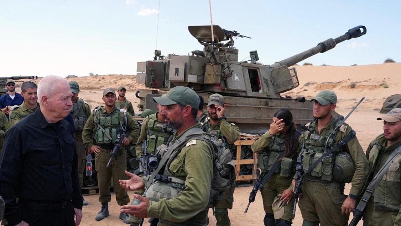 This handout picture released by the Israeli army on May 7, 2024 shows Israeli Defence Minister Yoav Gallant standing with soldiers by a self-propelled artillery howitzer during a visit to a position along the border with the Gaza Strip in southern Israel near Rafah. (Photo by Israeli Army / AFP) / === RESTRICTED TO EDITORIAL USE - MANDATORY CREDIT "AFP PHOTO / Handout / Israeli Army' - NO MARKETING NO ADVERTISING CAMPAIGNS - DISTRIBUTED AS A SERVICE TO CLIENTS ==