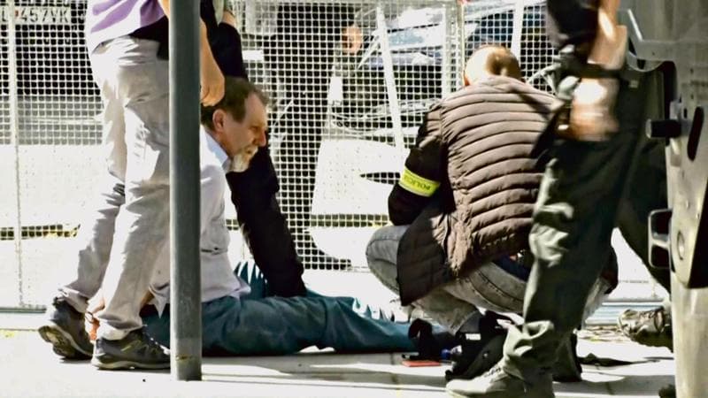 TOPSHOT - This image taken from video footage obtained by AFPTV shows security personnel apprehending a suspected gunman (C/GROUND) after Slovakia's Prime Minister was shot in Handlova on May 15, 2024. Slovakia's Prime Minister Robert Fico was battling life-threatening wounds after officials said he was shot multiple times in an assassination attempt condemned by European leaders. (Photo by RTVS / AFP)
