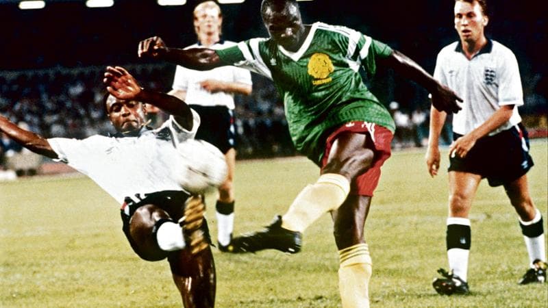 Roger Milla in azione contro Paul Parker e David Platt in Inghilterra-Camerun ai Mondiali 1990
