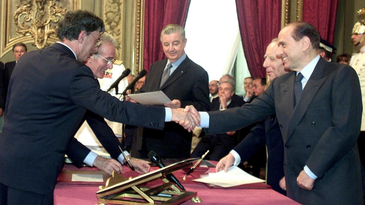 In una foto del 2001 il nuovo ministro delle Riforme Umberto Bossi stringe la mano al nuovo presidente del Consiglio Silvio Berlusconi  al Quirinale durante la cerimonia di giuramento del nuovo governo. ANSA / FILIPPO MONTEFORTE