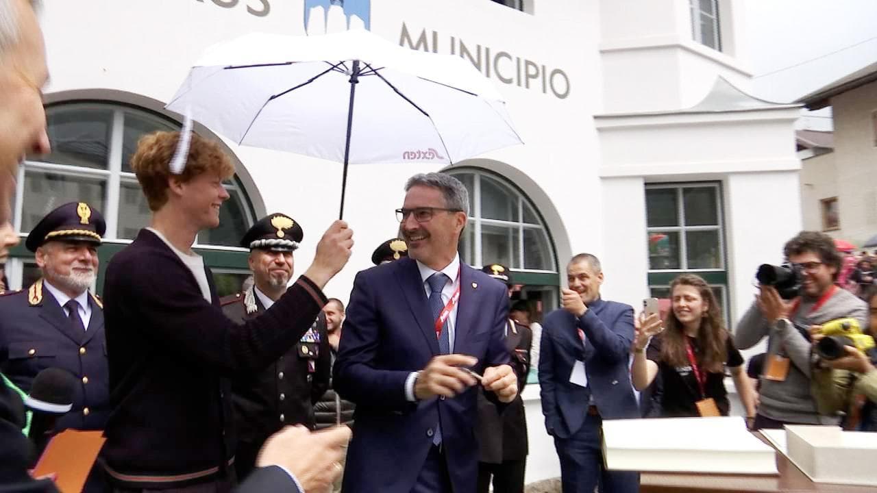 Sinner tiene l'ombrello alle autorità mentre riceve la cittadinanza onoraria di Sesto