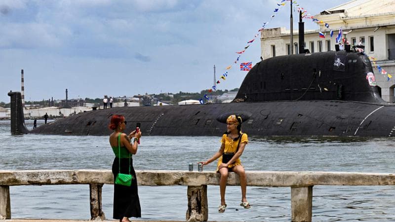 Due cubane si fanno foto davanti al sottomarino nucleare Kazan, una delle unità russe approdate nel porto dell'Avana.