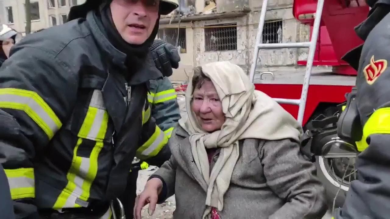 Anziani vengono soccorsi dai vigili del fuoco tra le fiamme dopo il bombardamento di un palazzo a Kiev