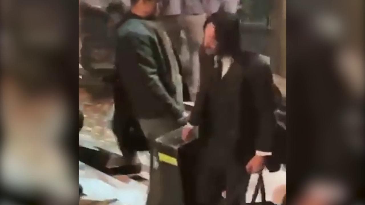 Parigi, Keanu Reeves aiuta la troupe a trasportare l'attrezzatura dopo una giornata di riprese