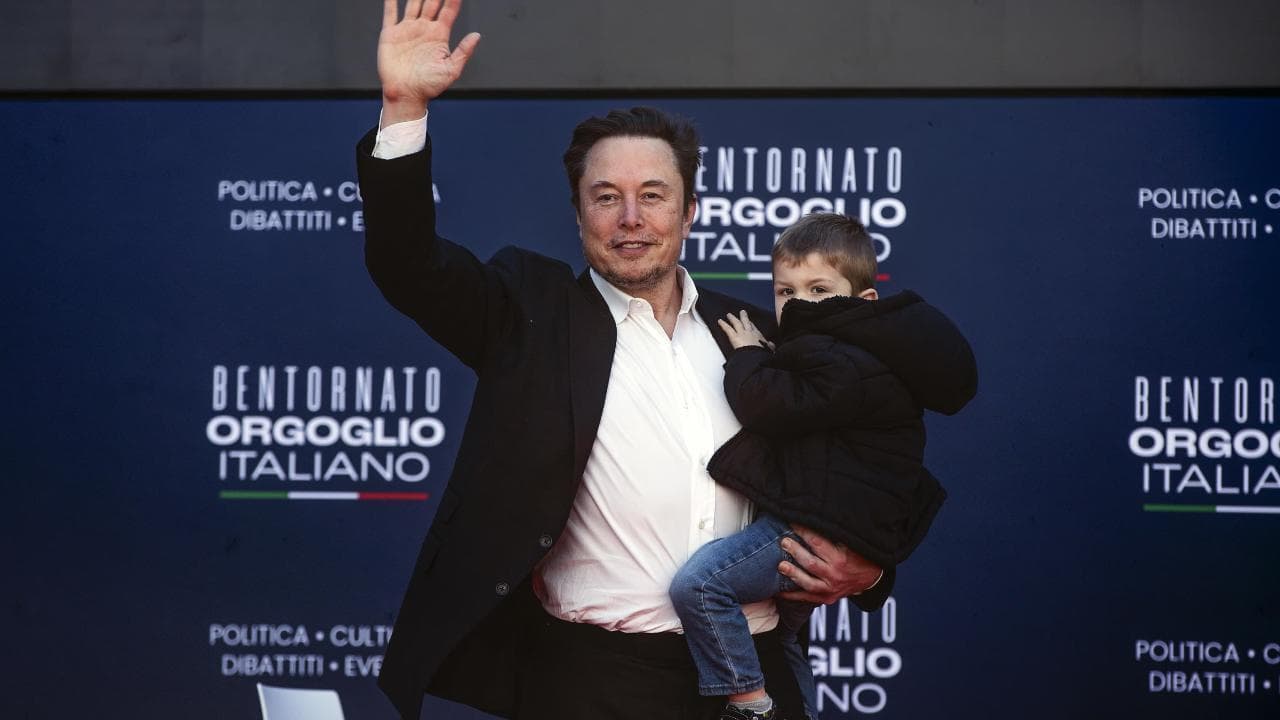 Atreju 2023, il messaggio di Musk: sul palco con uno dei suoi 11 figli prima in braccio, poi attaccato alla gamba